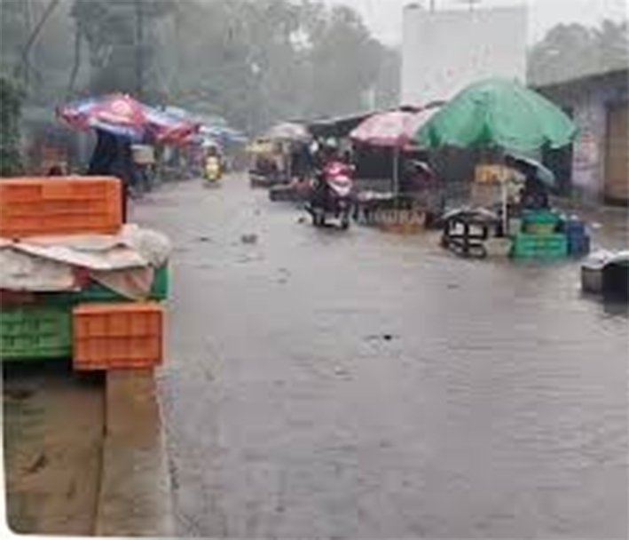 Vehicles and pedestrians moving through a waterlogged street in Kanyakumari during a heavy rainstorm on June 11, 2026.
