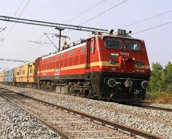 A long blue Indian Railways passenger train standing at a covered platform of Trichy Junction railway station in June 2026.