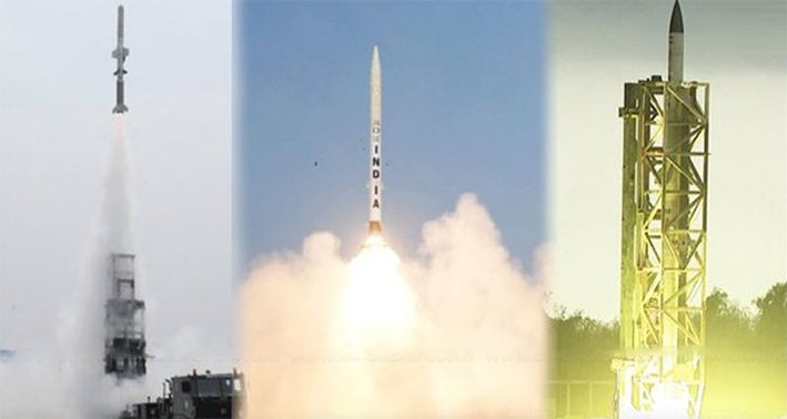 A powerful military missile launching from a coastal pad, leaving a massive trail of white smoke against a clear sky during a DRDO test in June 2026.